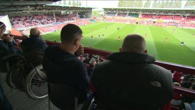 Disabled fans watch a football match