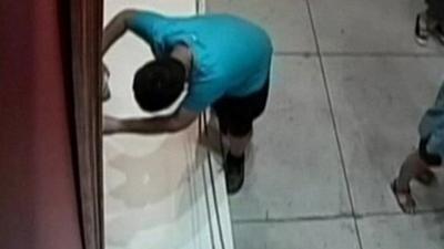 CCTV image captures the moment the boy trips and falls into the painting
