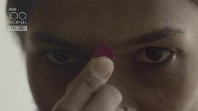 Woman putting on a bindi