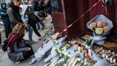 People leave floral tributes at the main entrance of Le Carillon restaurant on November 14, 2015 in Paris