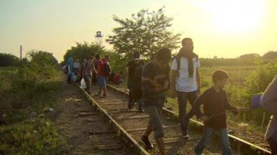 People walking along train tracks