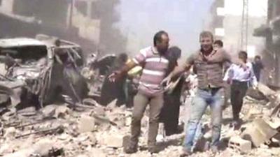 People walk in the rubble in Qamishli