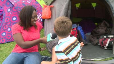 Ayshah talking to child outside tent