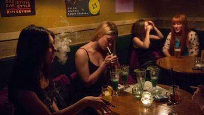 Girls smoke in a bar in central Moscow on May 30, 2014. Tough new anti-smoking legislation that comes into force on June 1