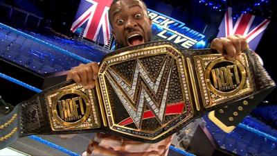 Kofi Kingston holding his championship belt