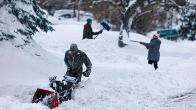 People clearing snow in Lakewood, Colorado.