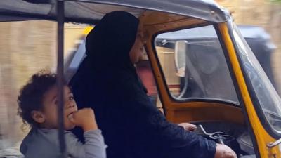 Composite photo of a woman driving a tuk-tuk