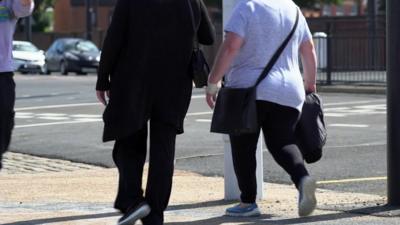 Two women walking on a street