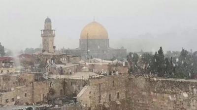 The Dome of the Rock vieweed from afar during the snowfall.