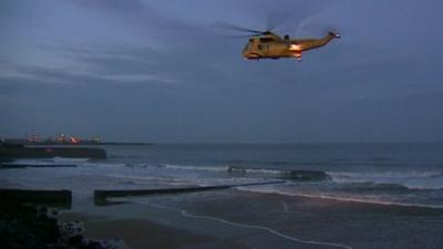Search and rescue helicopter over beach