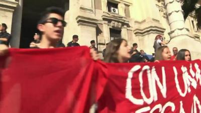 Protesting students hold up a banner