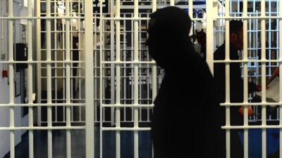 Silhouette of prisoner in front of bars