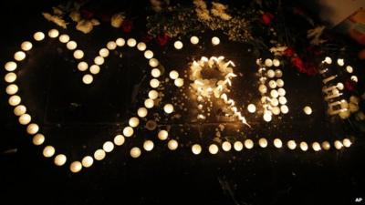 Candles placed to form the shape of a heart and the letters "R I P" at a memorial to victims of the Bangkok bombing