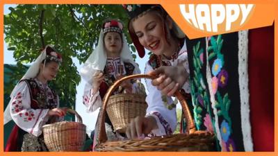 Girls with flower baskets and the Happy logo