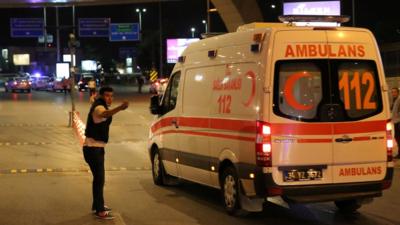 A policeman gestures in front of an ambulance at Istanbul Ataturk airport, Turkey, following a blast 28 June 2016.