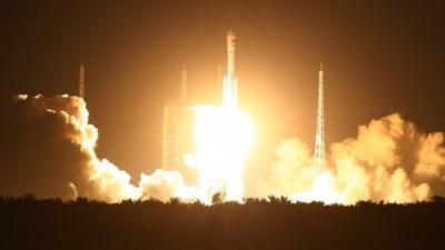 Spectators watch as a Long March 7 (CZ-7) rocket lifts off the launch pad in Wenchang in southern China"s Hainan Province