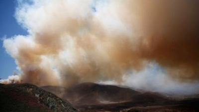 Plumes of thick smoke rise into the air across California as wildfires rage across the state.