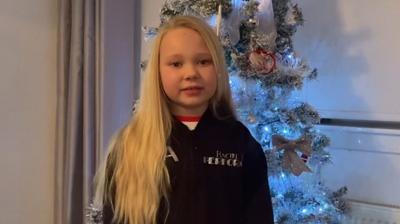 Young girl in front of Christmas tree