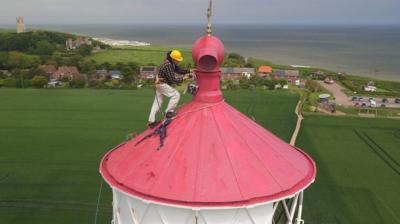 Man painting the top of Happisburgh lighthouse