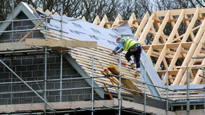 Construction site worker builds a roof