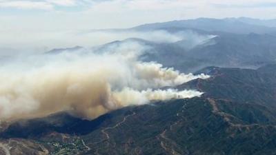 Aerial shot of plumes of smoke billowing from Big Sur State Parks in California as wild fires rage.