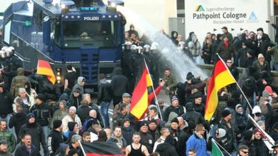 Police use a water cannon to drive back protesters at a demonstration by the far-right Pegida movement