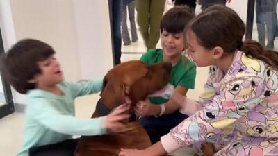 Yuval, Ofri and Oria Brodtz hug their dog Rodney