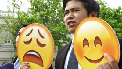 Filipino student holds up emojis