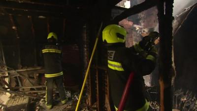 Firefighters damping down within fire affected buildings