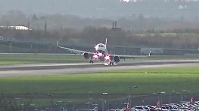 A British Airways plane struggles to land at Heathrow Airport as it approaches the runway.