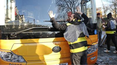 A man dressed as a bee glues himself to the Lib Dem bus