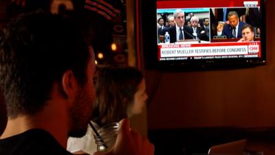 Two people watching the Mueller hearing