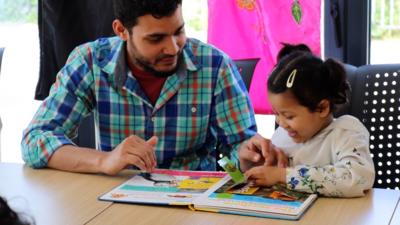 Man reading with his daughter