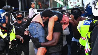 Mr Hutchinson lifting the injured man over his shoulder during the Black Lives Matter protest