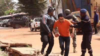 Mali troopers help a hostage leave the Radisson Blu hotel after an attack by gunmen Bamako, Mali, Friday, Nov. 20, 2015.