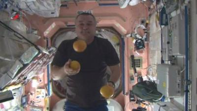 Spaceman juggles oranges