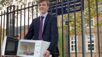 Kid carrying a microwave