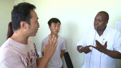 Chinese migrants being questioned by immigration official