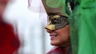 A costumed reveller smiles at St Mark's square (Piazza San Marco) during the Venice Carnival in Venice on January 30, 2016.