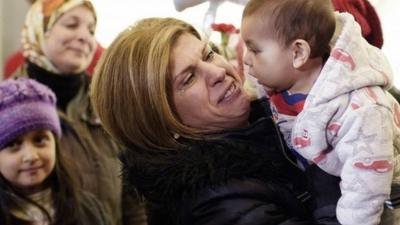 Tima Kurdi holds her nephew Sherwan Kurdi as she welcomes her brother Mohammed and his family