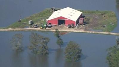 Texas farm building surrounded by floodwater