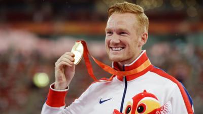 Long jump gold medallist Britain's Greg Rutherford holds up his medal during the medal ceremony at the World Athletics Championships at the Bird's Nest stadium in Beijing