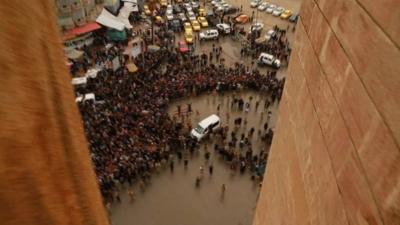 Crowd seen through buildings