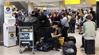 People wait at Heathrow Airport