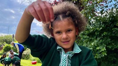 child holds worm