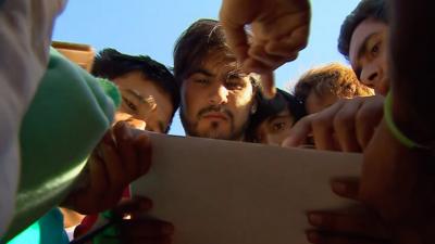 Migrants read name list at Hungary border