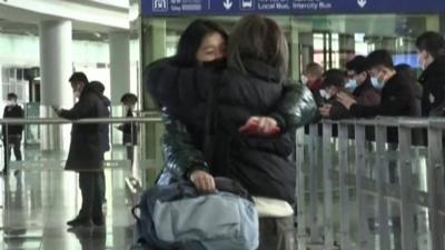 Traveller from Hong Kong hugs person meeting her in arrivals.