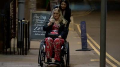 Helen Fincham being pushed along the street in her wheelchair