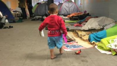 Young child and migrants sleeping in Keleti station subway