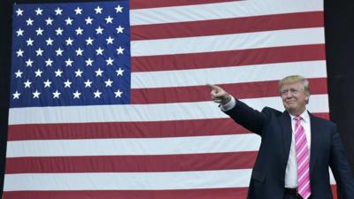 Donald Trump in front of a flag